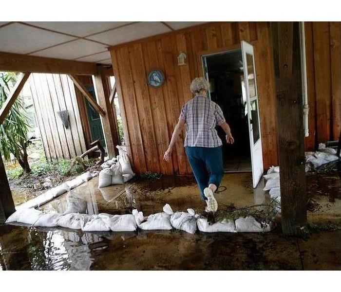a picture of a lady walking through a flooded patio