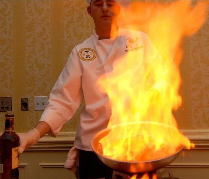 a chef with a pan on fire